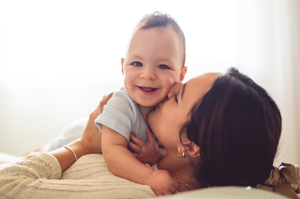 A happy baby at home with their mother